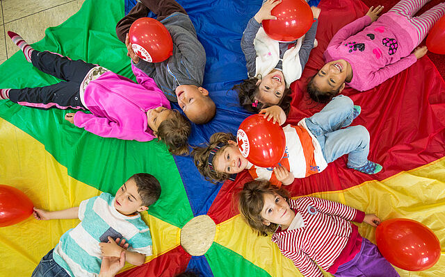 Kinder spielen mit Luftballons